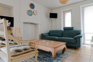 a living room with a couch and a coffee table at Le Valnotte - Proche plage et traversées iles in Barneville-Carteret