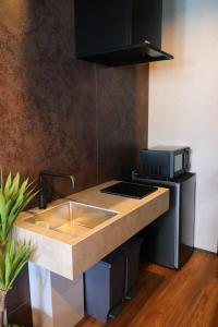 eine Küche mit Spüle und Mikrowelle in der Unterkunft Js STAY OTARU II in Otaru + 15 Fotos