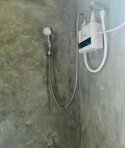 une douche avec un tuyau fixé à un mur dans l'établissement Windy Oasis, à Hikkaduwa 20 autres photos