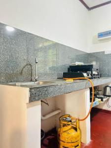 - un comptoir de cuisine avec évier et seau jaune dans l'établissement Windy Oasis, à Hikkaduwa