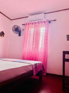 une chambre rose avec un lit avec un rideau rose dans l'établissement Windy Oasis, à Hikkaduwa