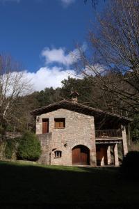 an old stone building with a balcony on top of it at Molí d'en Puig in Vall de Bianya