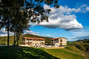 una casa en la cima de una colina cubierta de hierba en Tenuta La Farneta, en Casole dʼElsa