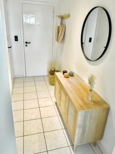 ein Badezimmer mit Spiegel und Fliesenboden in der Unterkunft Zeeparel in Nieuwpoort