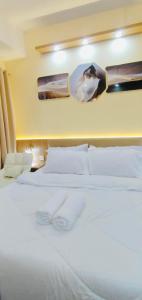 ein Schlafzimmer mit einem weißen Bett, auf dem zwei Handtücher liegen in der Unterkunft Morena Suite,Staycation,WiFi,Netflix,Near DLSU & Malls in Dasmariñas + 11 Fotos