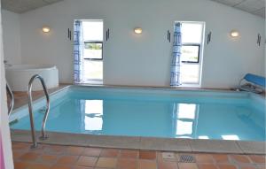 una piscina in una stanza con vasca e finestre di Awesome Home In Thisted With Sauna a Nørre Vorupør