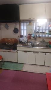 a kitchen with white cabinets and a sink at 民泊 瑞鳳館 in Senboku +14 photos