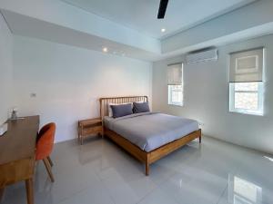 Un dormitorio con una cama y un escritorio. en Vila Pantai Sanur, en Sanur 38 fotos más