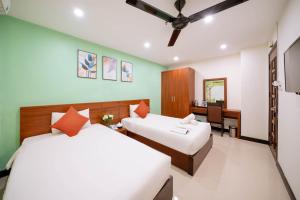 a hotel room with two beds and a desk at Quoc Cuong Center Da Nang Hotel by Haviland in Danang