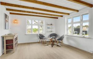 a room with two chairs and a desk and windows at Holiday Home Plantagevej Ringkøbing Xii in Søndervig