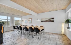 a dining room with a table and black chairs at Holiday Home Plantagevej Ringkøbing Xii in Søndervig
