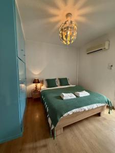 a bedroom with a green bed with a chandelier at XiangBaLa in Athens +47 photos