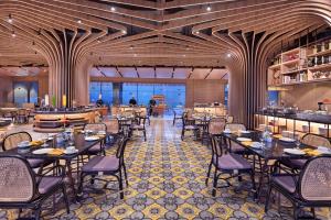 a restaurant with tables and chairs in a room at Grand Mercure Malang Mirama in Malang