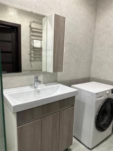 a bathroom with a washing machine and a sink at Dushanbe Place - Great Location in Dushanbe