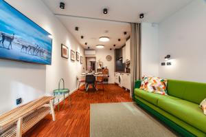 a living room with a green couch and a table at SIX IN THE CITY Apartment, LJUBLJANA in Ljubljana