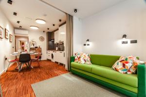a living room with a green couch and a table at SIX IN THE CITY Apartment, LJUBLJANA in Ljubljana