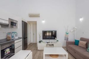 ein Wohnzimmer mit Couch und Fernseher in der Unterkunft Playa del Aguila Bungalow con Terraza Solarium in Maspalomas