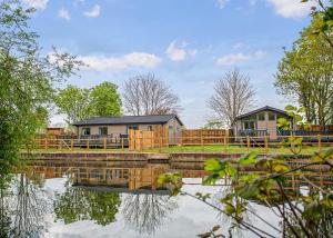 Un par de casas situadas junto a un cuerpo de agua. en Lee Valley, en Hoddesdon
