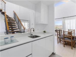 eine weiße Küche mit einem Waschbecken und einer Treppe in der Unterkunft La Manga Club Resort - Los Olivos 417 in Atamaría