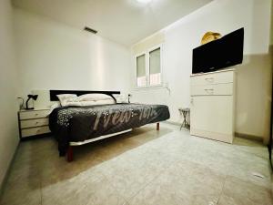 a bedroom with a bed and a flat screen tv at Global Immo 3390 Marítim 1A in Roses