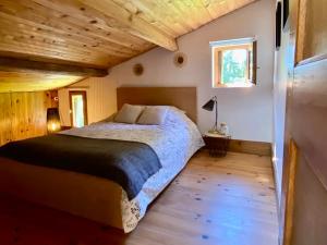 a bedroom with a bed and a wooden ceiling at Domaine Bourgade in Betbezer