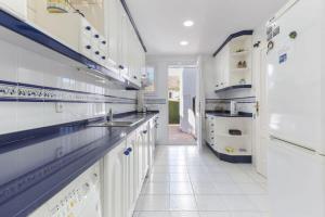 une cuisine avec des armoires blanches et un réfrigérateur blanc dans l'établissement Las Brisas 93, à Atamaría