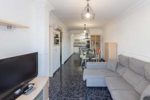 salon z kanapą i telewizorem z płaskim ekranem w obiekcie Lightbooking playa de Amadores La Concha w mieście Puerto Rico de Gran Canaria