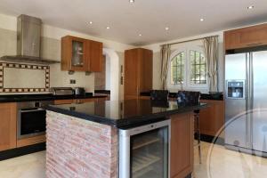 kuchnia z ceglaną wyspą w środku w obiekcie La Manga Club Resort - Individual Villa 559 w mieście Atamaría +25 zdjęć