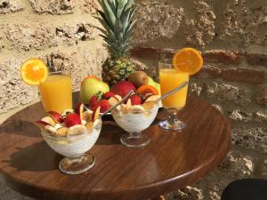 a table with bowls of fruit and two glasses of orange juice at Varosi Guesthouse in Edessa