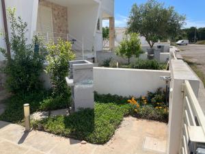 a garden in front of a house with flowers at Salentipity in Marina di Pescoluse