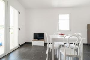 a white dining room with a white table and chairs at Salentipity in Marina di Pescoluse