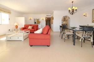 ein Wohnzimmer mit einem roten Sofa und einem Tisch in der Unterkunft La Manga Club Resort - Los Olivos 54 in Atamaría