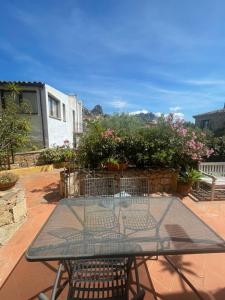una mesa y sillas en un patio con flores en Casa Migliore, en San Pantaleo