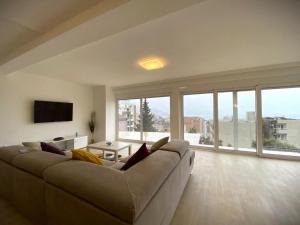 a large living room with a large couch and large windows at Apartments Marina in Bečići