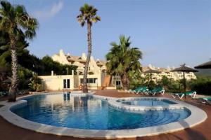 ein großer Pool mit Palmen und ein Haus in der Unterkunft La Manga Club Resort - Los Olivos 494 in Atamaría