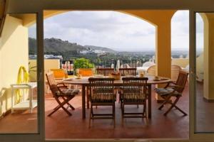 einen Esstisch und Stühle auf dem Balkon in der Unterkunft La Manga Club Resort - Los Olivos 494 in Atamaría