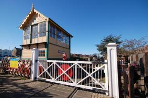 a small house behind a white gate with a building at 2 Museum Cottages in Sheringham +6 photos