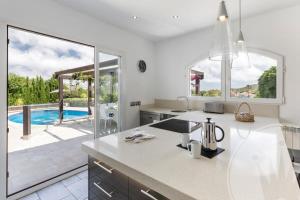 biała kuchnia z basenem w tle w obiekcie La Manga Club Resort - Individual Villa 524 w mieście Atamaría