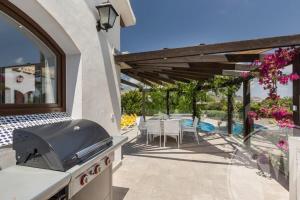 patio z grillem i stołem z krzesłami w obiekcie La Manga Club Resort - Individual Villa 524 w mieście Atamaría