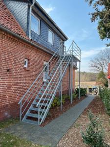 a metal staircase leading up to a brick building at Connys Ferienwohnungen Stern in Winsen Aller