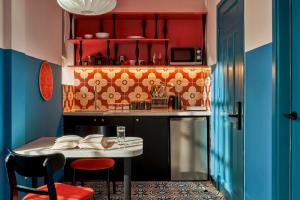 a kitchen with a small table and a kitchen with red cabinets at Dakao Vibe Studios by CIRCADIAN in Ho Chi Minh City +30 photos