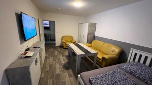 a small living room with a couch and a tv at Apartment Osnabrück Haste in Osnabrück