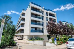 an apartment building with cars parked in front of it at Astria Mediterana - Complex Novum in Olimp