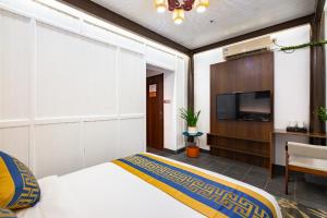 a bedroom with a bed and a flat screen tv at Huangshan Chuyuyuan Manju Homestay in Huangshan