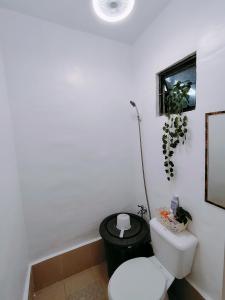 a bathroom with a white toilet and a black trash can at Home in Pagadian City near airport in Norte