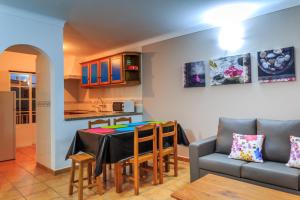 a kitchen and living room with a table and a couch at Casas do Zé in Odeceixe +15 photos