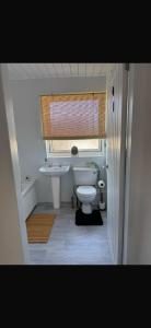 a bathroom with a toilet and a sink and a window at Haste Ye Back in Inverness +17 photos