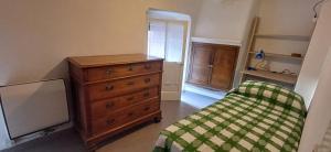 a bedroom with a bed and a dresser and a window at Casa Zanetti in Bovegno
