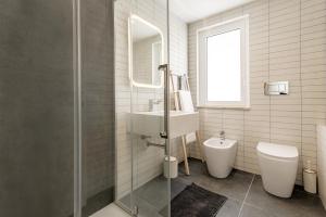 ein weißes Badezimmer mit Waschbecken und Toilette in der Unterkunft Casa Suli Beachfront in Marina di Ragusa + 22 Fotos