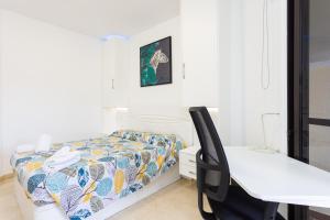 a bedroom with a desk and a bed with a bedspread at Apartamento con vistas al océano in Puerto de la Cruz +21 photos